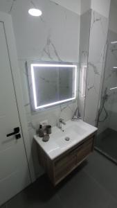 a white bathroom with a sink and a mirror at Golem Horizon apartment in Golem +45 photos