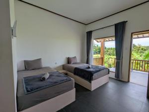 two beds in a room with a balcony at Medewi Sunrise in Medewi +37 photos