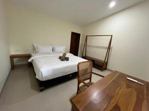 a bedroom with a bed with a table and a mirror at Kapal dream in Selong Belanak
