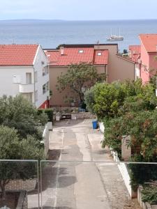 a walkway between buildings with the ocean in the background at Golden Panorama in Novalja