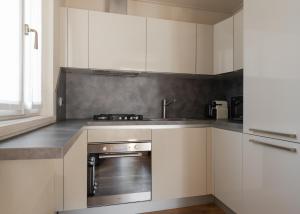 a kitchen with white cabinets and a stainless steel oven at Jolie Maison by Villa Porta Collection in Luino