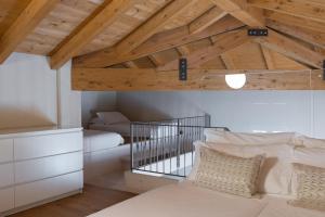 a bedroom with a bed and a wooden ceiling at Jolie Maison by Villa Porta Collection in Luino