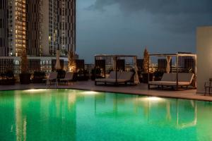 马六甲Dusit Princess Melaka的夜间在建筑物屋顶上的游泳池