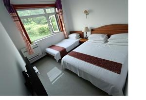 Un pat sau paturi într-o cameră la Gubeikou Great Wall Juxian Residents' Lodging