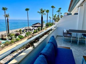 a couch on a balcony with a view of the beach at VIP Dominion Beach Estepona in Estepona