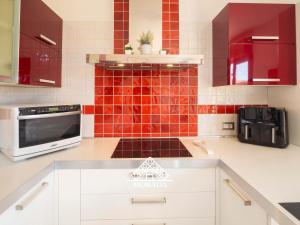 una cucina con piastrelle rosse sul muro di Casa Maura - MORADA a Iglesias Altre 19 foto