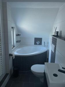 a bathroom with a tub and a toilet and a sink at Ferienwohnung Teichblick in Altenburg +72 photos