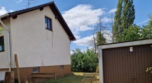 a house with a garage next to a building at Chalet Corallo con camino e ingresso indipendente in Ronco