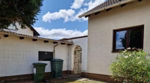 a house with two trash cans in front of it at Chalet Corallo con camino e ingresso indipendente in Ronco