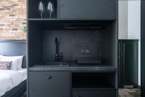 a kitchen with a sink in a bedroom at Numa Prague Root in Prague
