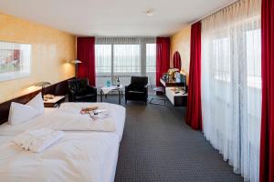 a hotel room with two beds and a desk at Hotel Roth am Strande in Westerland
