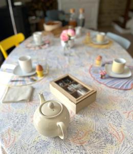 a table with a tea pot and a box on it at L'échappée belle in Luc-sur-Mer