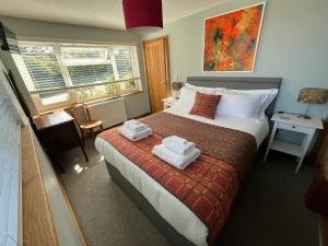 a bedroom with a bed with towels on it at Ty Boia Bed & Breakfast in St. Davids
