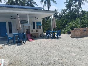 a patio with chairs and tables and umbrellas at Cabana Chalet Cherating in Cherating