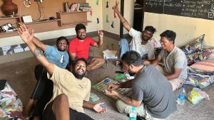 蒂鲁瓦纳马莱Ulala Hostels - Feels like HOME的一群坐在地上玩棋盘游戏的人