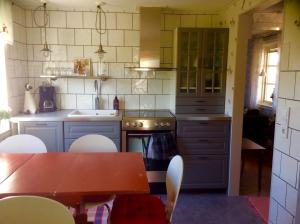 a kitchen with a table and a table and chairs at Farbror Alfreds Stuga Sjöutsikt in Köpingsvik