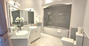 a bathroom with two sinks and a shower and a toilet at Manor Of Groves Hotel, Golf & Health Club in Sawbridgeworth