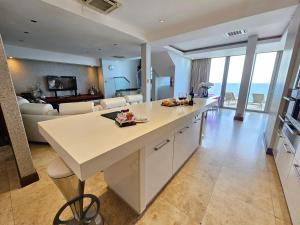 a kitchen and living room with a large white island at Exquisite Penthouse Apartment 712 at La Montagne by First Private Stays in Ballito