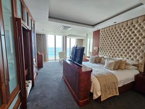 a bedroom with a large bed and a television at Exquisite Penthouse Apartment 712 at La Montagne by First Private Stays in Ballito