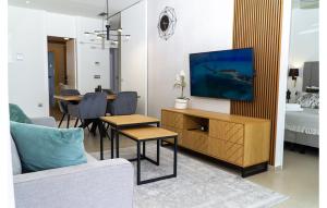 a living room with a television on a wooden cabinet at Intempo Apartment 2F by VivaMar in Benidorm