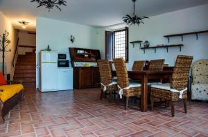 a living room with a table and chairs and a kitchen at Monti sibillini house in Pievebovigliana