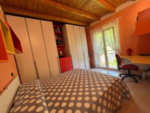 a bedroom with a bed and a desk and a window at Penthouse Valentino in Intra