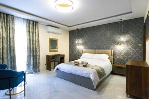 a bedroom with a bed and a desk and a chair at Luxury Seaside Eastlynn Flat Ghadira, Mellieha in Mellieħa