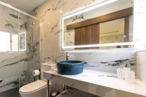 a bathroom with a sink and a toilet and a mirror at Luxury Seaside Eastlynn Flat Ghadira, Mellieha in Mellieħa