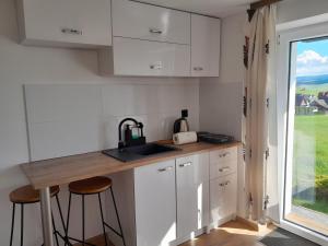 斯洛莫夫采维日奈Apartamenty w Pieninach - studio 2 osobowe的厨房配有白色橱柜、水槽和窗户