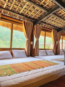 Un dormitorio con dos camas grandes con ventanas. en Ngũ Chỉ Sơn Trekking Sapa Homestay Local Experience, en Sa Pa