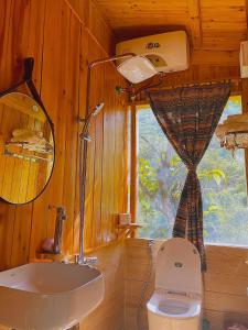 Un baño con inodoro, lavabo y espejo. en Ngũ Chỉ Sơn Trekking Sapa Homestay Local Experience, en Sa Pa