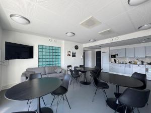 a living room with tables and chairs and a couch at Kotimaailma - Vihtyisä Hostelli in Kokkola +25 photos