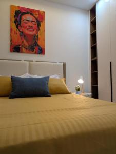 a bedroom with a bed with a painting on the wall at Dar GAMRA Luxury apartment with sea view in Hammamet Sud