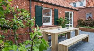 于斯德Nordhaus的砖砌建筑前的木制野餐桌和长凳