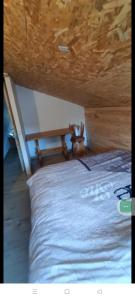a bed in a room with a wooden ceiling at Chalet 5 personnes avec piscine in Yvoir +6 photos