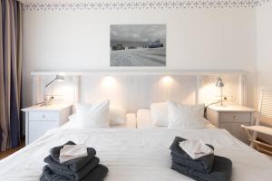 a bedroom with a white bed with two pillows on it at Wohnung 14 Am Januspark in Juist