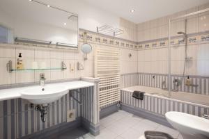 a bathroom with a sink and a bath tub and a sink at Wohnung 14 Am Januspark in Juist +14 photos