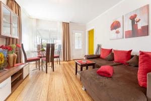 - un salon avec un canapé brun et des oreillers rouges dans l'établissement Kajüte Nr 1, à Neue Tiefe Fehmarn 26 autres photos