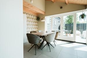 a dining room with a wooden table and chairs at Dorpsweg 9 - Ouddorp in Ouddorp