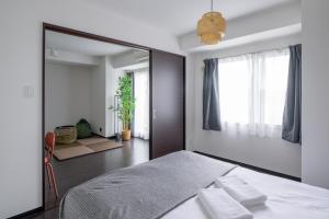 a bedroom with a bed and a large mirror at Sun North in Sapporo