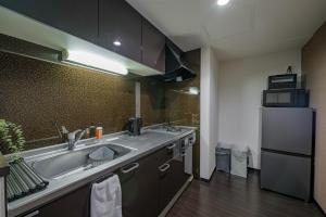a kitchen with a sink and a refrigerator at Sun North in Sapporo +74 photos