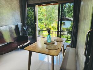 a table with a vase on it in a room with a window at Bantai Hideaway - House 1 in Baan Tai