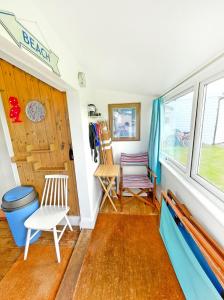 a room with two chairs and a window at Cool Seaside Hut, Sandy & Quiet Norfolk Beach in Bacton