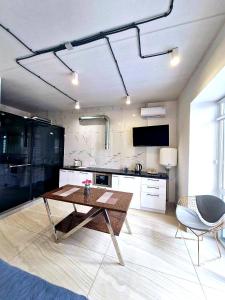 a living room with a table and a kitchen at Stylish apartments in the city center in Rivne