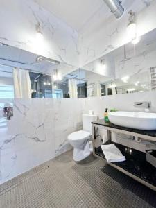 a bathroom with a sink and a toilet and a tub at Stylish apartments in the city center in Rivne