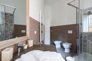 a bathroom with a toilet and a glass shower at G-House Pettinari in Rome