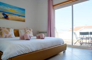 a bedroom with a bed with a view of a patio at The Lazy Sunbathers, Praia del Rei, Óbidos, B11 in Óbidos +10 photos