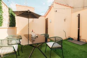 a patio with a table and chairs and an umbrella at Ático Cierzo Nuevo Duplex Terraza WiFi 1 BR in Zaragoza