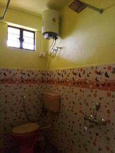 a bathroom with a toilet and a window at Matti I Pa Homestay in Cherrapunji