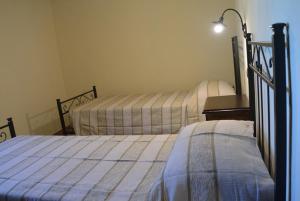 una camera con 2 letti e una lampada di Agriturismo Dei Setteventi a Santa Luce